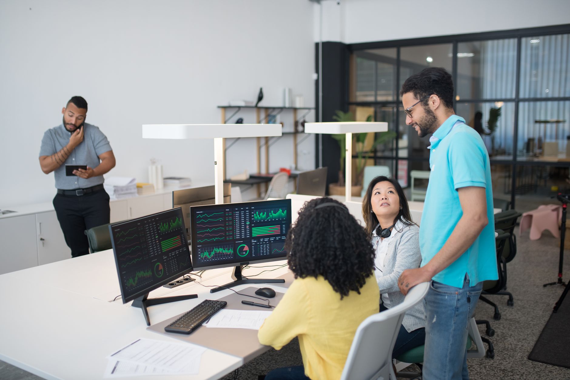 Dans un espace de travail moderne, les employés de bureau collaborent sur des données financières, favorisant le travail d'équipe et la communication.